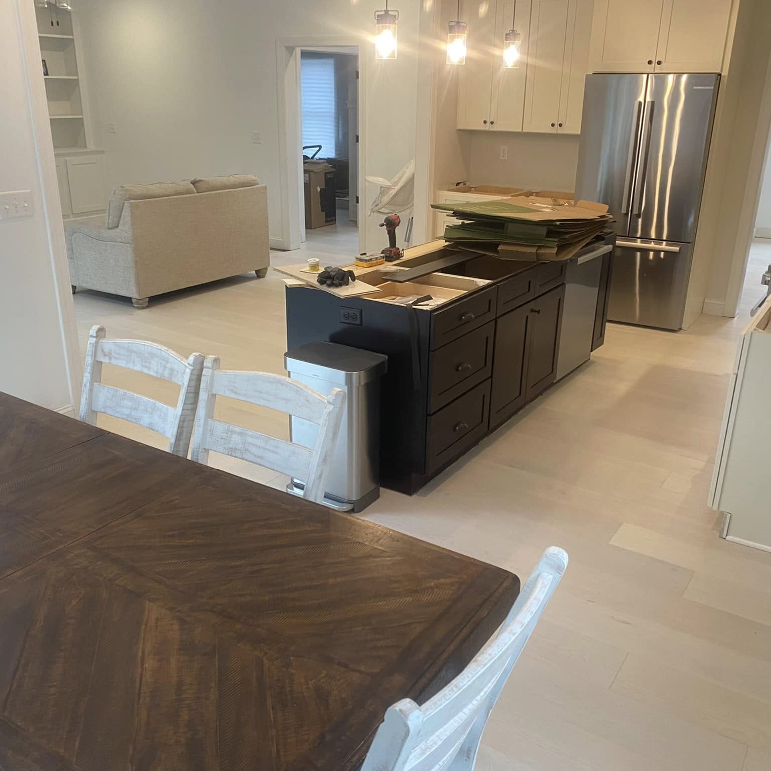 Light wood flooring running through an open kitchen and dining area